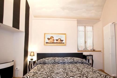 a bedroom with a bed and a picture on the wall at Comfortable studio in Piazza, 30 m², fireplace & balcony in Mondovì