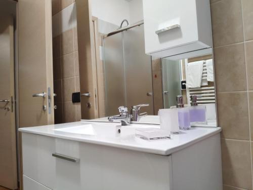 a bathroom with a white sink and a mirror at Bilocale in corte a Boltiere (BG) in Boltiere