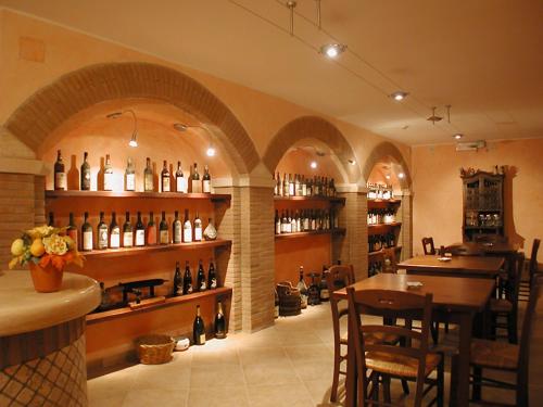 - une salle de dégustation de vin avec une table et des étagères de bouteilles de vin dans l'établissement Hotel Dimora Adriana, à Tivoli