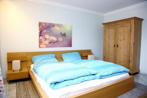 um quarto com uma cama com cobertores azuis em 2 bedrooms appartement with indoor pool enclosed garden and wifi at Sauerlach em Sauerlach