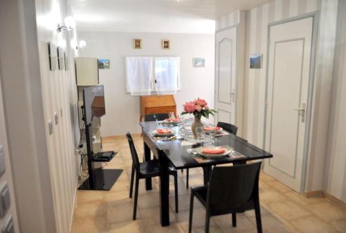 une salle à manger avec une table et des chaises noires dans l'établissement Maison charmante à Gargas avec piscine privée., à Gargas