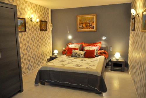 une chambre avec un lit avec des oreillers rouges dans l'établissement Maison charmante à Gargas avec piscine privée., à Gargas