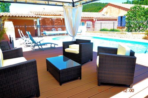 - une terrasse avec des chaises et une table à côté de la piscine dans l'établissement Maison charmante à Gargas avec piscine privée., à Gargas