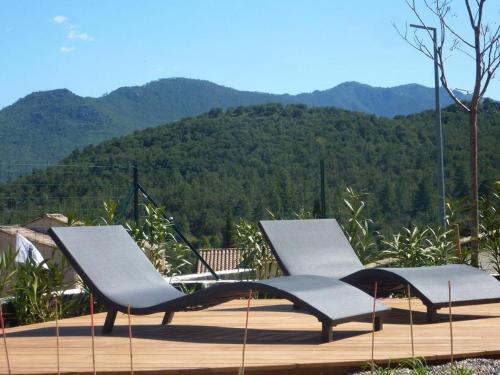 twee stoelen op een terras met bergen op de achtergrond bij Appartement de 2 chambres avec jardin clos et wifi a Morosaglia in Morosaglia