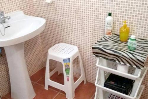 a bathroom with a sink and a stool next to a sink at One bedroom house with garden at Triquivijate in Antigua