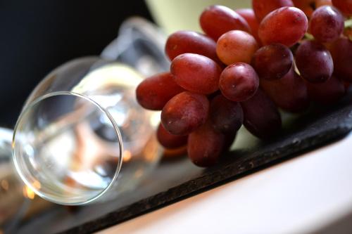 a bunch of grapes on a tray next to a wine glass at Ferienhaus Maja in Cochem