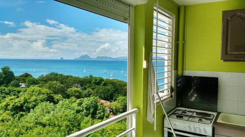 a kitchen with a window with a view of the ocean at Appartement moderne à Sainte-Anne 43 m² avec vue mer in Sainte-Anne