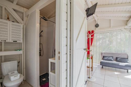 a bathroom with a toilet and a window at Bungalow charmant à Petit Bourg avec piscine partagée in Petit-Bourg