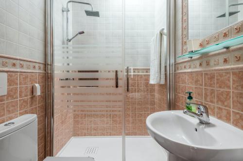 y baño con ducha, lavabo y aseo. en 2 bedrooms house at Nerja 300 m away from the beach with sea view private pool and furnished terrace, en Nerja