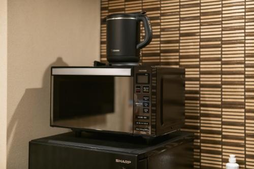 a microwave with a coffee cup on top of it at GRAND BASE Urakami in Nagasaki