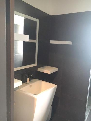 une salle de bain avec un lavabo blanc et un miroir dans l'établissement Villa spacieuse avec piscine privée et vue montagne à Prades, à Prades