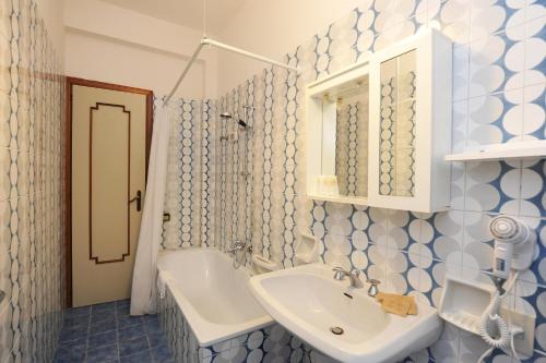 a blue and white bathroom with a sink and a mirror at One bedroom apartement at Maiori 50 m away from the beach with furnished balcony and wifi in Maiori