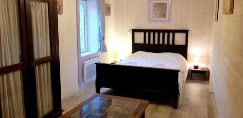 une chambre avec un lit, une fenêtre et une table dans l'établissement Maison charmante à Bussac-Forêt avec piscine partagée, à Bussac-Forêt