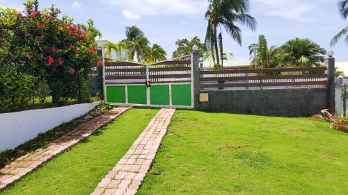 a garden with a fence and a grass yard at Appartement d'une chambre avec jardin clos et wifi a Baie Mahault in Baie-Mahault