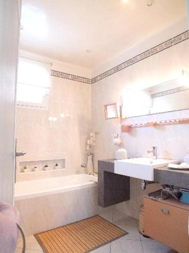 une salle de bain avec une baignoire et un lavabo dans l'établissement Maison chaleureuse à Orange avec piscine privée, à Orange