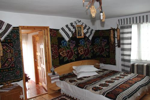 a bedroom with a large bed with a floral wallpaper at Pensiunea Casa Alex in Sadova