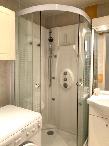 une douche avec une porte vitrée dans une salle de bain dans l'établissement Appartement cosy à Argelès-sur-Mer 30 m² avec piscine partagée, à Argelès-sur-Mer