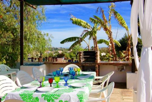 uma mesa com pratos e copos num pátio em 6 bedrooms villa with sea view private pool and wifi at Loule em Loulé