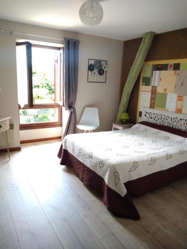 a bedroom with a bed and a window at La Ferme Fleurie in La Roque-Gageac