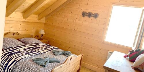 een slaapkamer met een bed in een blokhut bij Chalet de 4 chambres avec jardin amenage a Les Avanchers Valmorel a 7 km des pistes in Les Avanchers