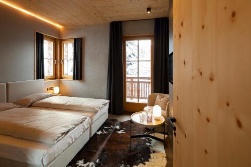 een slaapkamer met een bed, een tafel en een raam bij Chalet Cirmolo in Livigno
