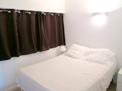 a bedroom with a white bed and a window at Appartement lumineux à Saint-Cyprien 45 m² vue mer in Saint-Cyprien