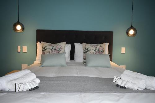a bedroom with a large bed with towels on it at Mosswood Bed & Breakfast in Graskop