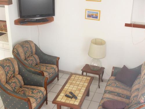 a living room with two chairs and a tv at Villa de 2 chambres avec piscine privee jardin amenage et wifi a Sisteron in Sisteron