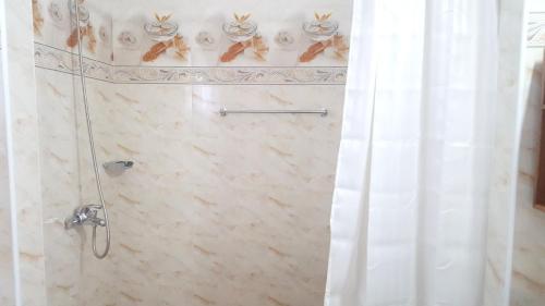 a bathroom with a shower with a shower curtain at One bedroom appartement with sea view enclosed garden and wifi at Baie Sainte Anne 5 km away from the beach in Baie Sainte Anne