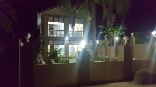 a fence in front of a house at night at Comfortable apartment in Baie Sainte Anne 56 m² with sea view in Baie Sainte Anne