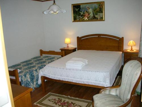 um pequeno quarto com uma cama e 2 cadeiras em 2 bedrooms villa with shared pool jacuzzi and enclosed garden at Pedraca em Pedraça