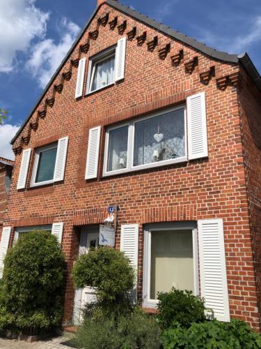 a red brick house with two cats in the window at Möwenflug Apartments in Travemünde