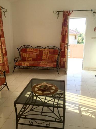 a living room with a couch and a glass table at Bright apartment with sea view and garden in Ouoran, 100 m² in Ouoran