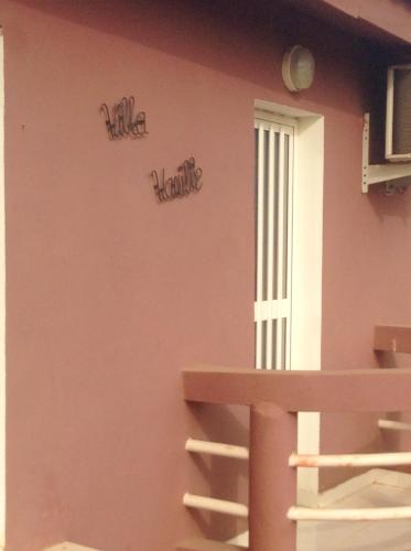 a wall with two signs on the side of a building at Bright apartment with sea view and garden in Ouoran, 100 m² in Ouoran