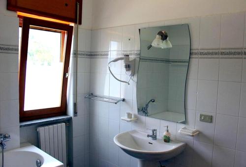 a white bathroom with a sink and a mirror at One bedroom apartement with wifi at Calvello in Calvello