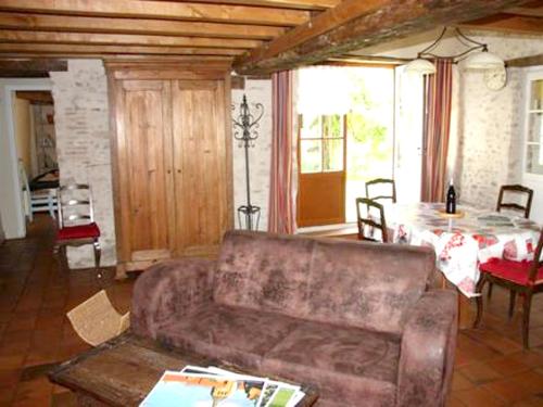 una sala de estar con un sofá y una mesa en Maison confortable avec jardin à Mardié + Terrasse, en Mardié