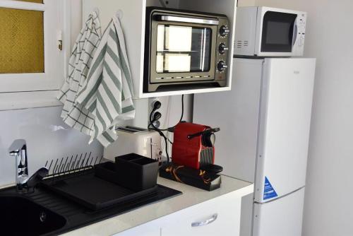 a kitchen with a sink and a microwave at Studio avec vue sur la ville balcon et wifi a Baie Mahault in Baie-Mahault