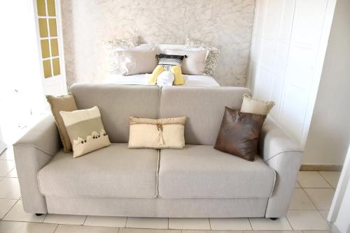 un sofá con almohadas y un osito de peluche. en Studio avec vue sur la ville balcon et wifi a Baie Mahault, en Baie-Mahault