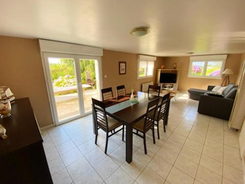 une salle à manger et un salon avec une table et des chaises dans l'établissement Appartement spacieux vue mer Trévou, à Trévou-Tréguignec