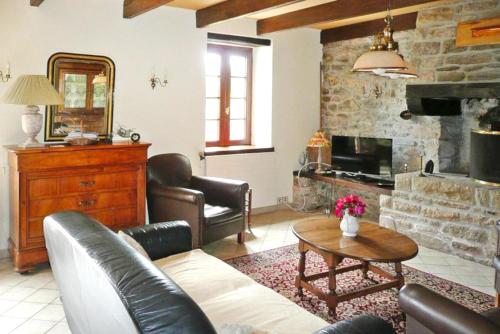 un salon avec un canapé et une cheminée dans l'établissement Maison confortable proche de Ploudalmézeau avec jardin, à Ploudalmézeau