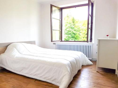 uma grande cama branca num quarto com uma janela em Maison de 3 chambres avec jardin clos et wifi a Quebriac em Québriac