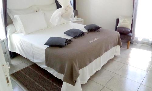 a bedroom with a white bed with pillows on it at Bungalow charmant à Sainte-Anne in Sainte-Anne