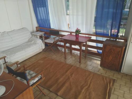 a living room with a couch and a table at 3 bedrooms house at Marina di Ravenna 400 m away from the beach with enclosed garden and wifi in Marina di Ravenna