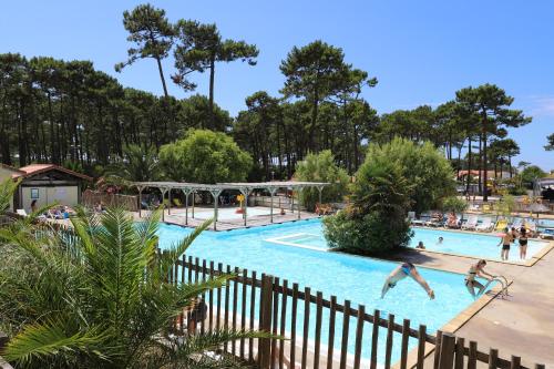 a pool at a resort with people playing in it at Camping Campéole Plage Sud - Maeva in Biscarrosse