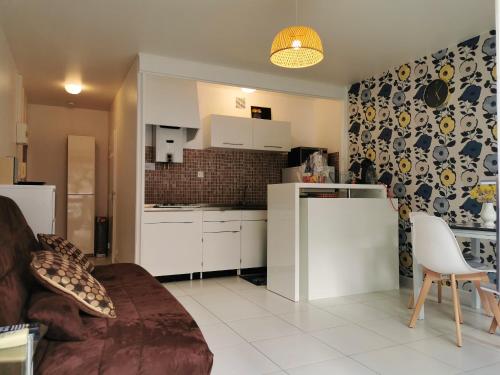 un salon avec une cuisine équipée d'appareils blancs dans l'établissement Studio charmant à Saint-Cyprien - 25 m² avec balcon, à Saint-Cyprien