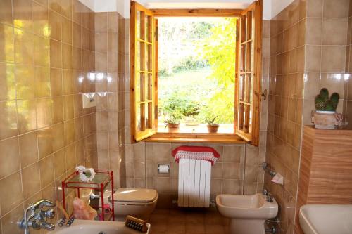 łazienka z oknem, toaletą i umywalką w obiekcie Charming House near Monteciccardo with Private Pool w mieście Monteciccardo