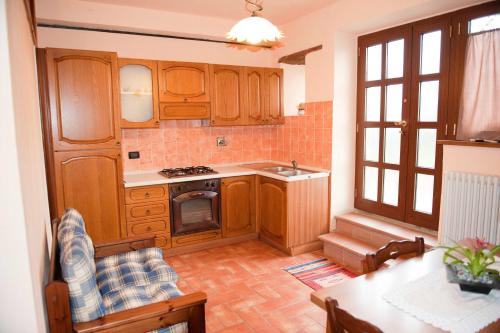 a kitchen with wooden cabinets and a stove top oven at Charming house in Caprese Michelangelo with shared pool in Arezzo