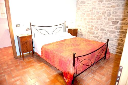 een bed in een kamer met een bakstenen muur bij One bedroom house with shared pool garden and wifi at Caprese Michelangelo in Arezzo