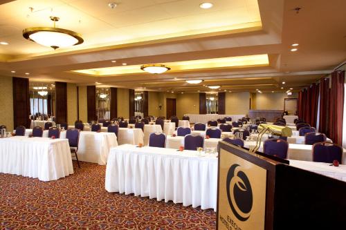 a banquet hall with white tables and blue chairs at Executive Hotel Vancouver Airport in Richmond