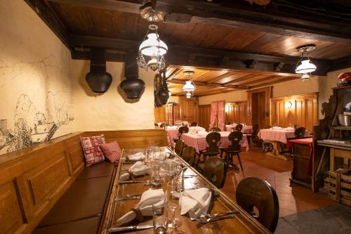 ein Restaurant mit Tischen und Stühlen in einem Zimmer in der Unterkunft Hotel Bären in Gsteig